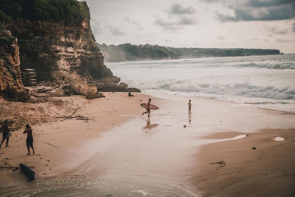 Des surfeurs marchant sur la plage.